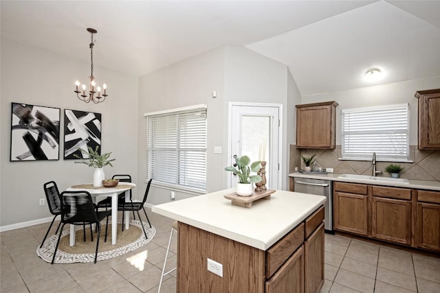 kitchen featuring sink, hanging light fixtures, a center island, light tile patterned flooring, and stainless steel dishwasher