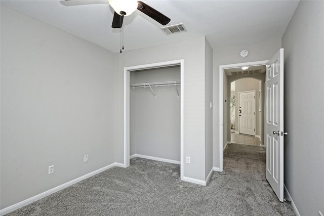 unfurnished bedroom with ceiling fan, carpet floors, and a closet