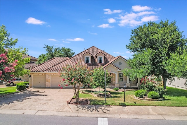 mediterranean / spanish house with a garage and a front yard