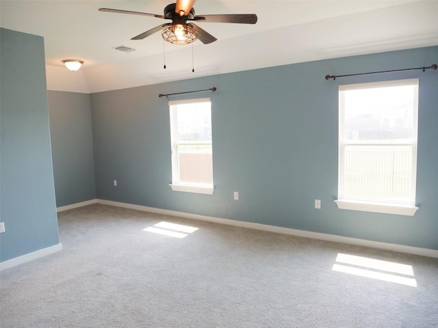 carpeted spare room featuring vaulted ceiling and ceiling fan