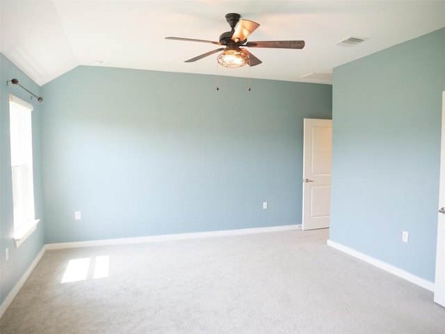 spare room featuring vaulted ceiling, light carpet, and ceiling fan