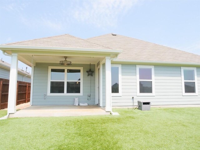 rear view of house featuring a patio, ceiling fan, and a lawn