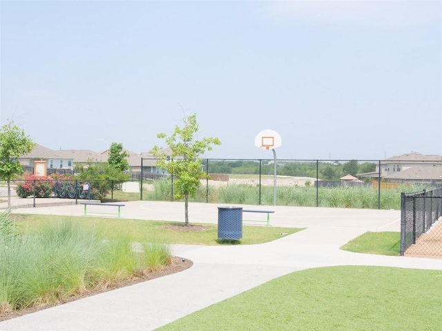 view of home's community with a yard and basketball court