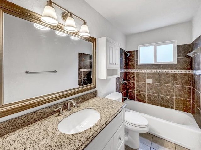 full bathroom featuring vanity, tiled shower / bath combo, tile patterned floors, and toilet