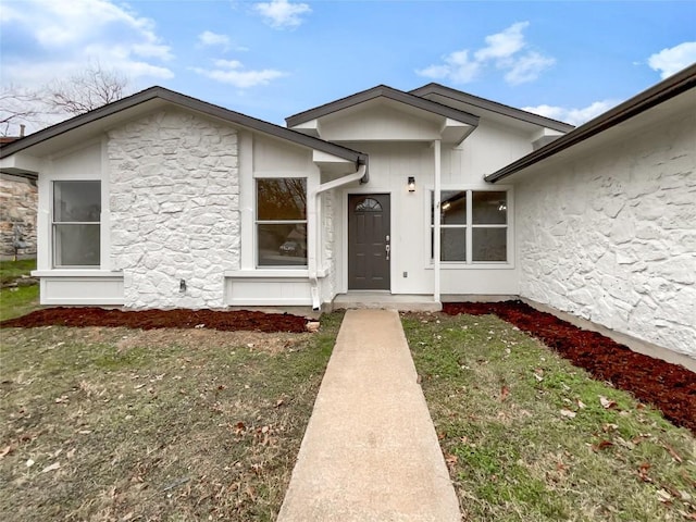 property entrance featuring a lawn