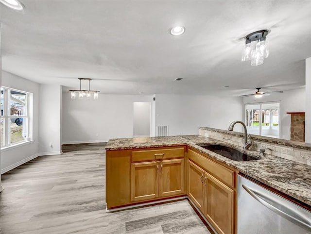 kitchen with sink, light hardwood / wood-style flooring, stainless steel dishwasher, kitchen peninsula, and pendant lighting