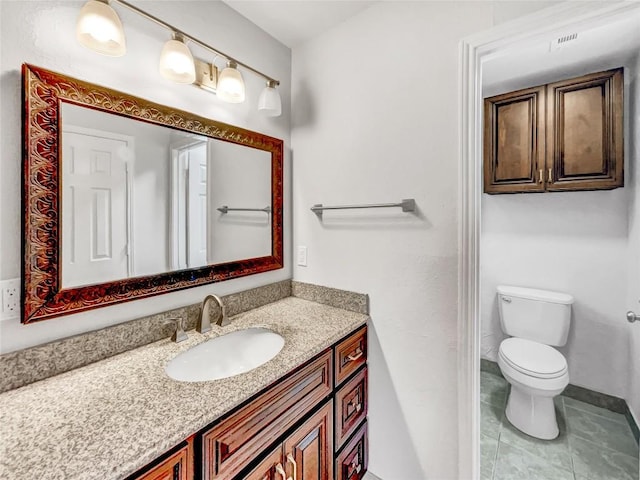 bathroom featuring tile patterned flooring, vanity, and toilet