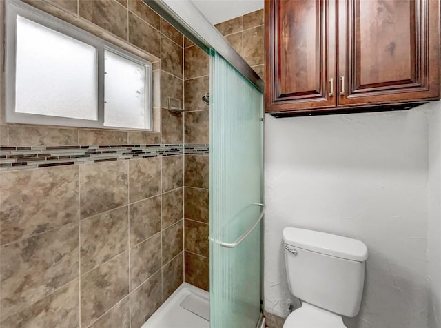 bathroom featuring toilet and a shower with shower door