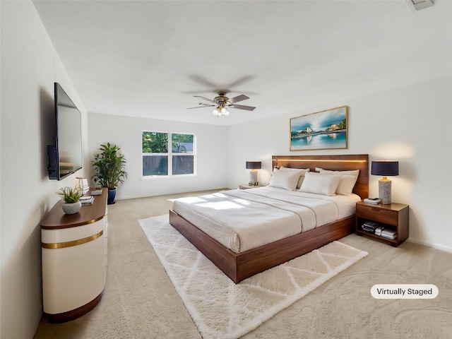 bedroom featuring light colored carpet, baseboards, and ceiling fan