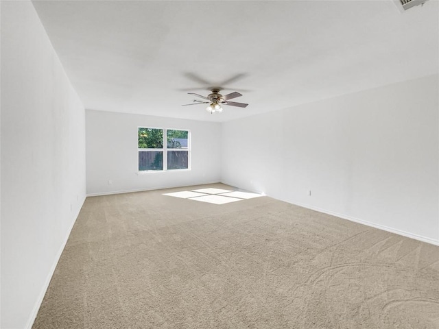spare room with carpet, ceiling fan, and baseboards