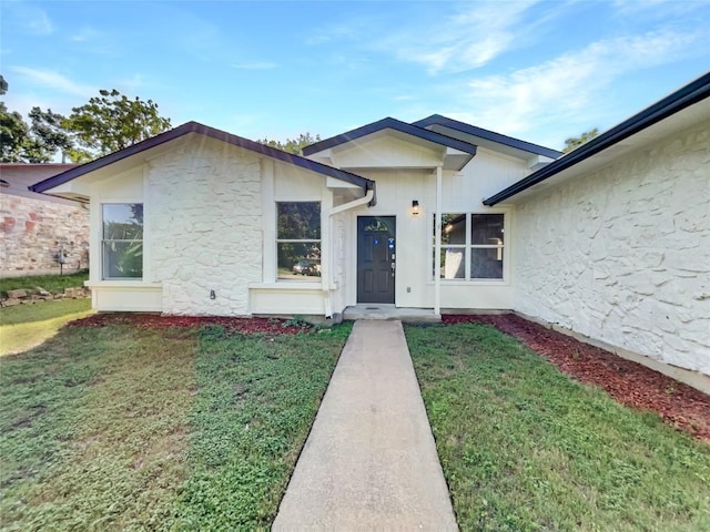 8222 Kearsarge Dr, Austin, TX 78745 - view of front of home with a front lawn, stone siding, and stucco siding