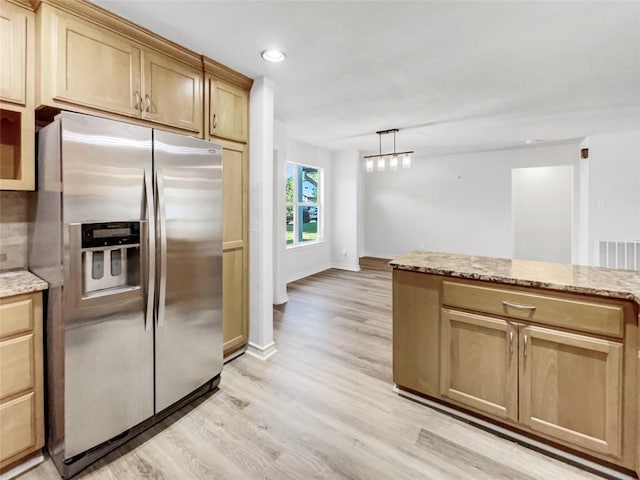 kitchen with stainless steel refrigerator with ice dispenser, light wood finished floors, light stone countertops, recessed lighting, and baseboards