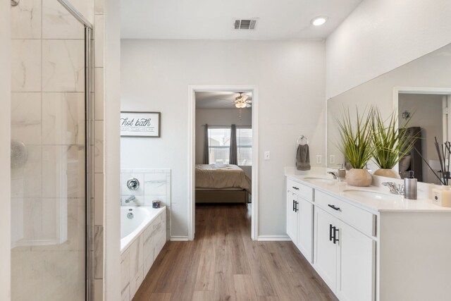 bathroom with independent shower and bath, wood-type flooring, vanity, and ceiling fan