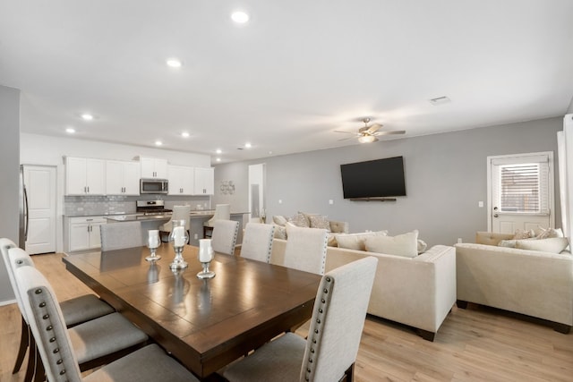 dining room with ceiling fan and light hardwood / wood-style flooring