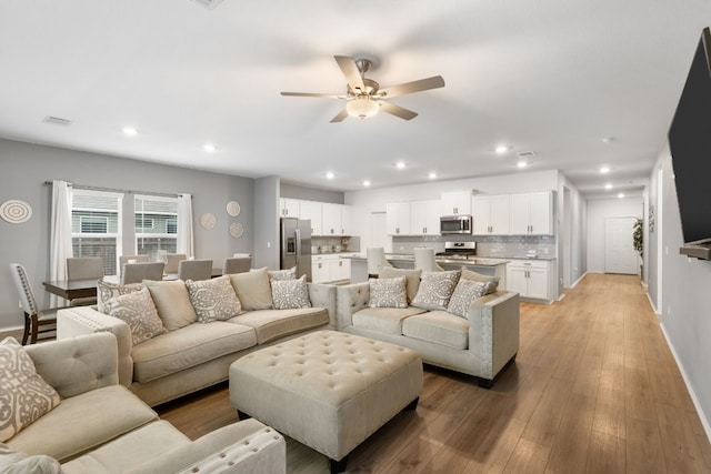 living room with ceiling fan and light hardwood / wood-style floors