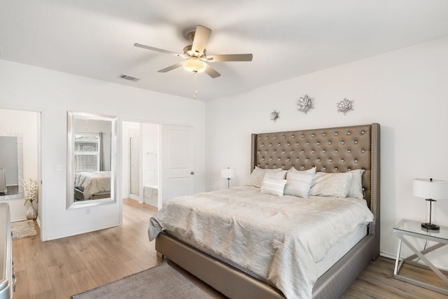 bedroom with ensuite bath, light hardwood / wood-style flooring, and ceiling fan