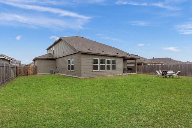 rear view of house featuring cooling unit and a lawn