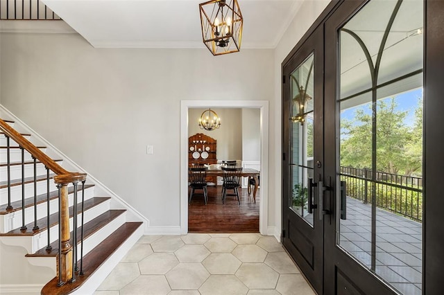 foyer with a wealth of natural light, an inviting chandelier, and french doors