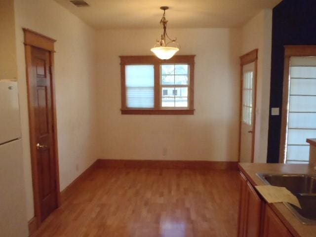 unfurnished dining area featuring sink and hardwood / wood-style floors