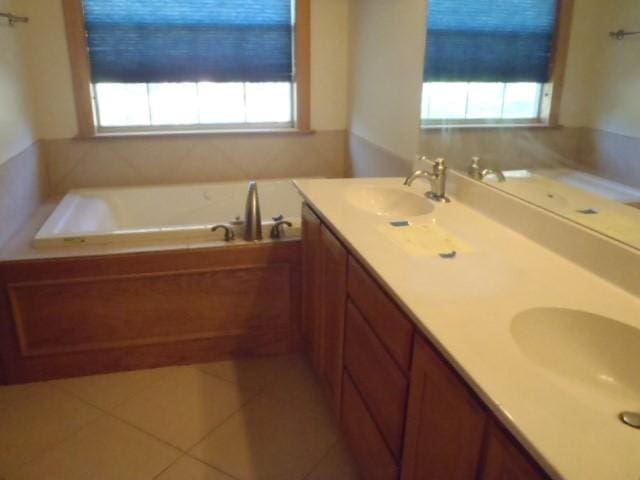 bathroom with tile patterned flooring, vanity, and a bathtub