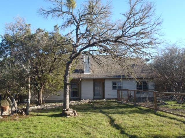 rear view of property featuring a lawn