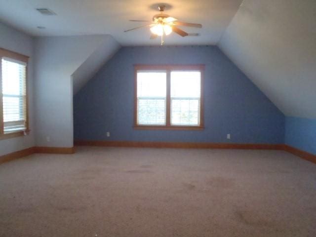 bonus room featuring ceiling fan, plenty of natural light, vaulted ceiling, and carpet