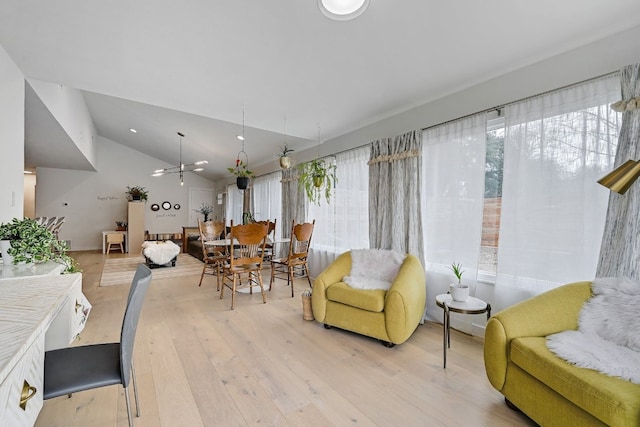 living room with a chandelier, vaulted ceiling, and light wood-type flooring