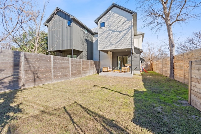 rear view of property with a yard and a patio