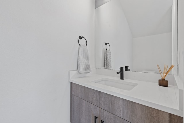 bathroom featuring vanity and lofted ceiling