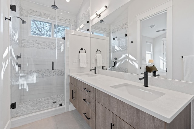 bathroom with tile patterned flooring, vanity, vaulted ceiling, and walk in shower