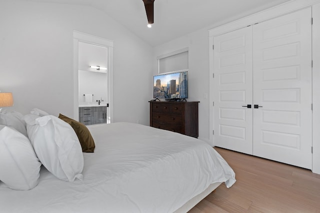 bedroom featuring lofted ceiling, ensuite bathroom, a closet, hardwood / wood-style flooring, and ceiling fan