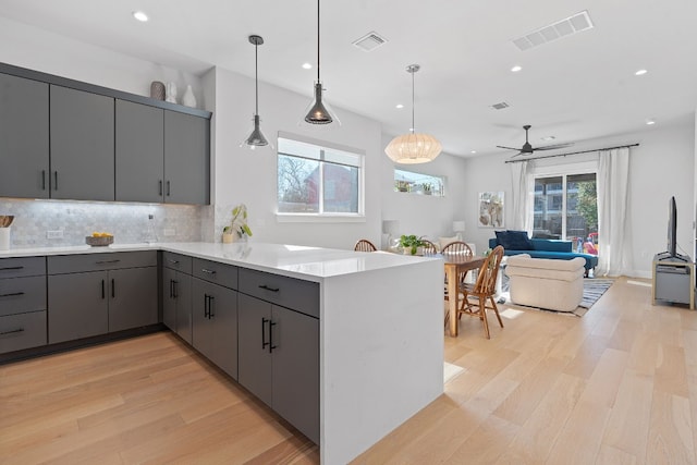 kitchen with pendant lighting, kitchen peninsula, and gray cabinetry