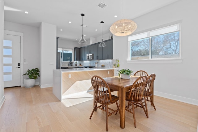 dining space with a wealth of natural light and light wood-type flooring