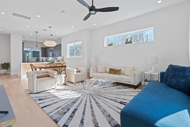 living room with ceiling fan and light wood-type flooring