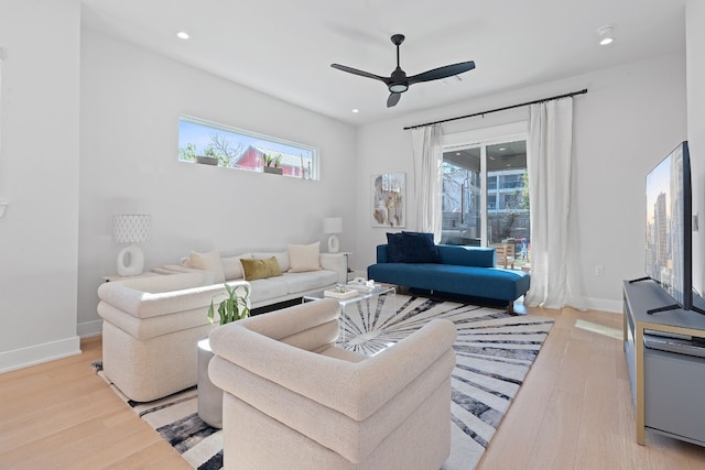 living room with light hardwood / wood-style flooring and ceiling fan