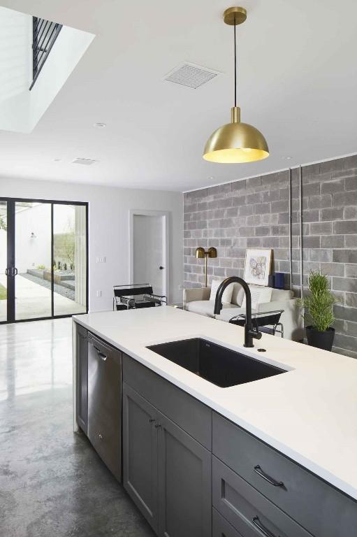 kitchen featuring gray cabinets, sink, stainless steel dishwasher, and decorative light fixtures