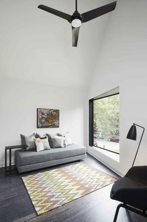 living room featuring ceiling fan, dark hardwood / wood-style floors, and high vaulted ceiling