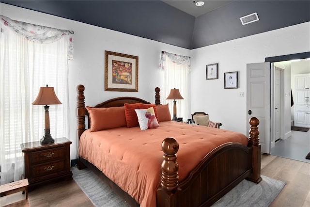 bedroom with ensuite bathroom and light wood-type flooring