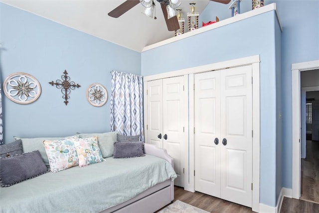 bedroom with dark wood-type flooring, ceiling fan, vaulted ceiling, and a closet