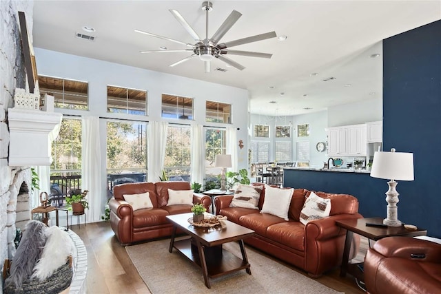 living room featuring ceiling fan and light hardwood / wood-style flooring