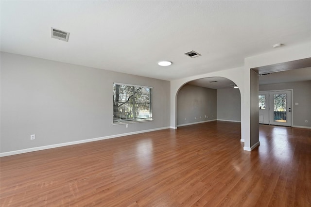 unfurnished room featuring plenty of natural light and hardwood / wood-style floors