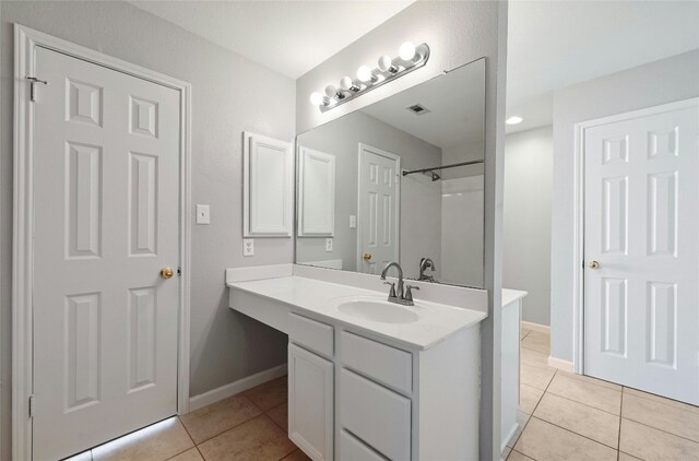 bathroom featuring vanity, tile patterned floors, and walk in shower