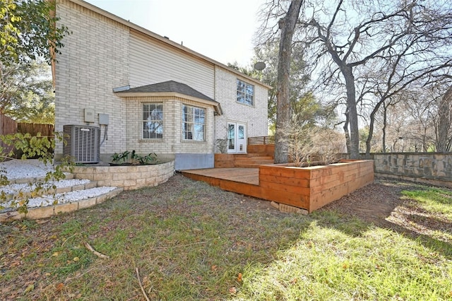 rear view of house with brick siding, fence, a deck, and central AC unit