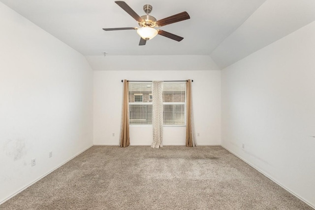 carpeted spare room featuring lofted ceiling and ceiling fan