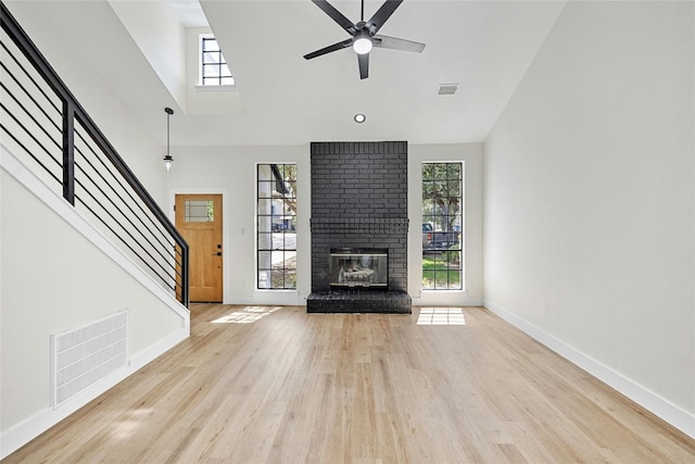 unfurnished living room with a fireplace, light hardwood / wood-style floors, and ceiling fan