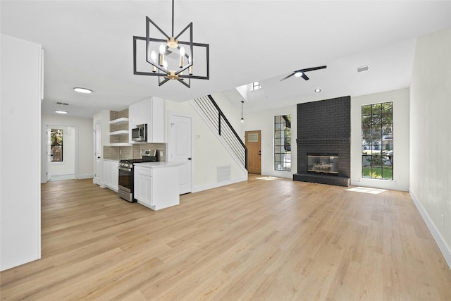 kitchen with white cabinetry, tasteful backsplash, hanging light fixtures, light hardwood / wood-style flooring, and stainless steel appliances