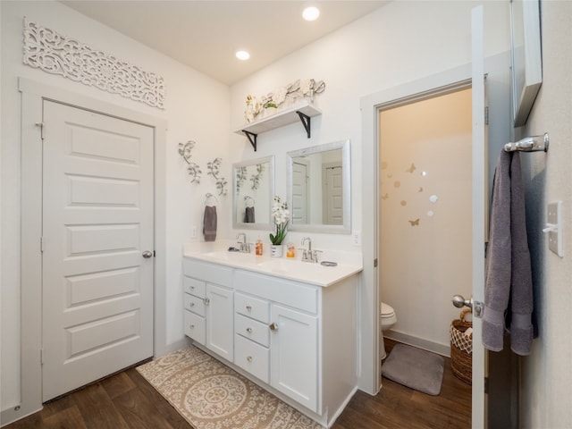 bathroom with vanity, toilet, and hardwood / wood-style floors