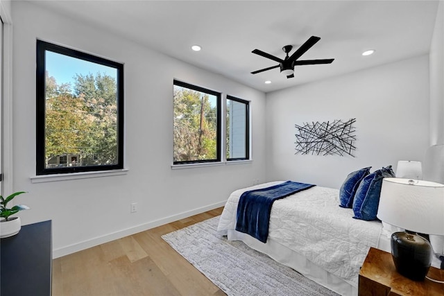 bedroom featuring multiple windows, ceiling fan, and light hardwood / wood-style floors