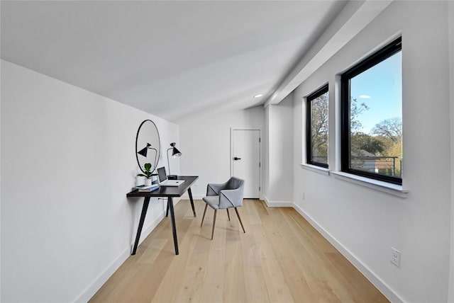 hallway featuring vaulted ceiling and light hardwood / wood-style flooring