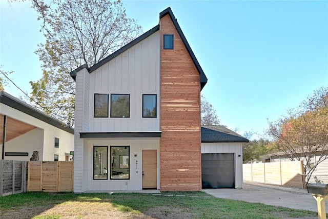 back of house with a garage and a lawn